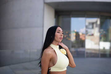 young woman in yello short dress walking on the street in the evening