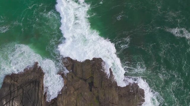 Evening Drone Crane Up Revealing Rocky Cliff and Foamy Waves by Cyan Sea