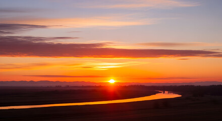 Spectacular sunset over a winding river reflects golden light on the water surface