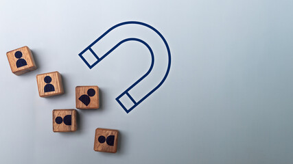 Customer attraction and lead generation concept with a magnet pulling wooden blocks of people icons. Idea of marketing strategy, business growth, recruitment, and digital customer engagement.