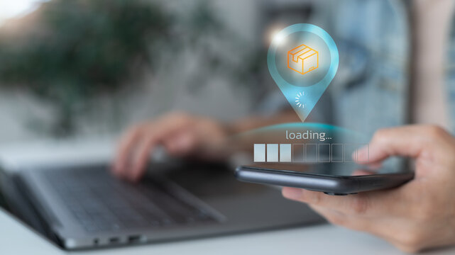 Online package tracking concept showing digital loading status on a smartphone with a laptop background, modern logistics technology, e-commerce shipping, and smart delivery system. - Powered by Adobe