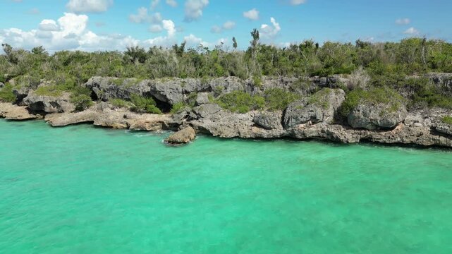 4K drone footage of El Penon &mdash; emerald-blue ocean and rocky cliffs under bright Caribbean skies