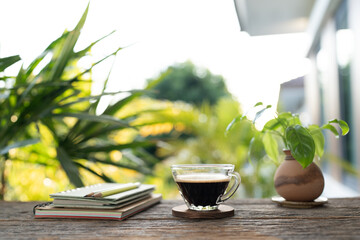 coffee glass cup and notebook, green pencils on old wooden table, outdoor chill relaxing scene for writing