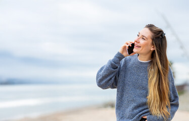 Happy young woman talking on phone outdoors