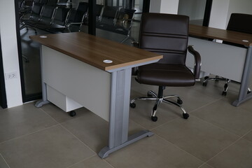 Brown leather office chair sits in front of a wooden desk