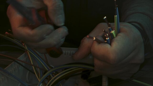 the hands of an electrician stripping wires