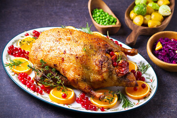 Roasted whole duck with fuits and berries served on oval side dish plate