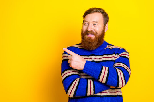 Young bearded man in a casual striped sweater gesturing with his hand against a vibrant yellow background - Powered by Adobe