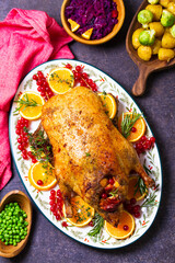 Roasted whole duck with fuits and berries served on oval side dish plate. High angle view