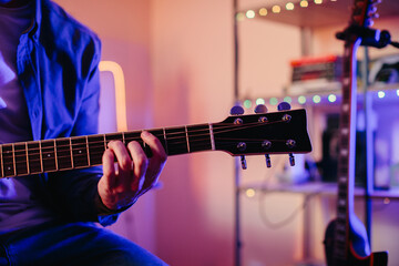 Fototapeta premium Musician composing music playing acoustic guitar at home studio