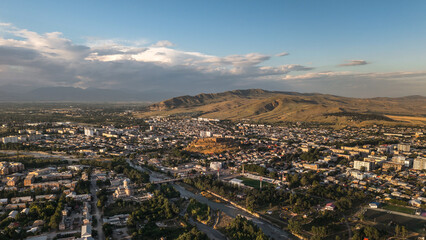 Drone view of Gori city with river, houses, and fortress surrounded by mountains