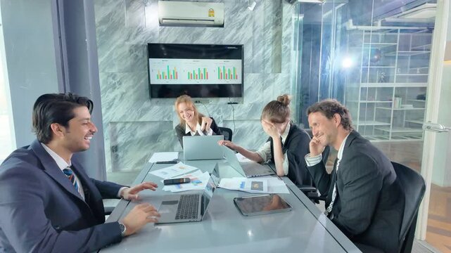 Business Meeting Laughter: A group of diverse professionals in a modern office setting share a moment of lighthearted laughter during a business meeting.