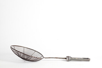 metal spider strainer skimmer used for cooking isolated on a clean white background