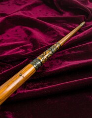 Fototapeta premium Wooden wand on deep maroon fabric