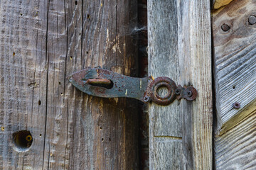 Close-up of an old metal handle on a wooden door