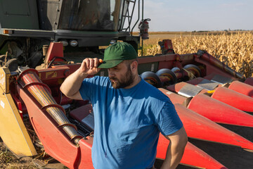 Farmer stands next to the harvester