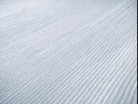 Pristine ski slope surface with groomed trail marks ready for winter sports recreation