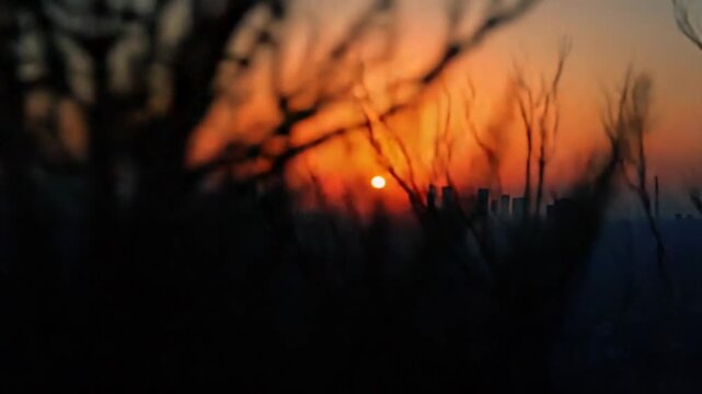 Time lapse of the sun sets behind the skyline of the city at sunset light
