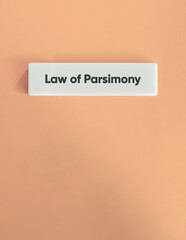 Law of Parsimony Text on White Tile with Soft Pink Background