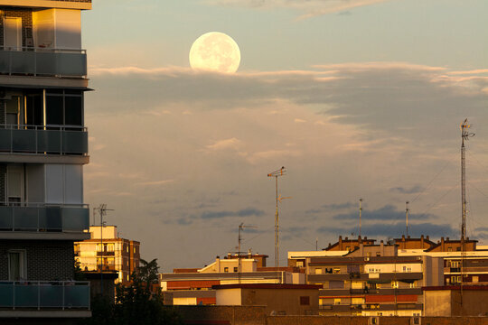 Puesta de luna llena tras las nubes en la ciudad de Fuenlabrada, Madrid, Espa&ntilde;a
