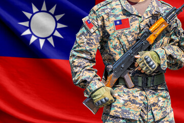 Fototapeta premium Taiwan flag with soldier in military uniform holding assault rifle in front of it