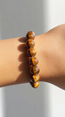 Tiger's Eye Bracelet: A close-up view of a hand adorned with a tiger's eye gemstone bracelet, showcasing the stone's chatoyancy in natural light, adding an element of elegance and mystique.