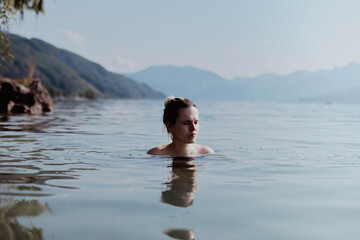 Mujer  en lago de montaña. Schwimmen im See mit Bergen. Swimming in lake with mountains
