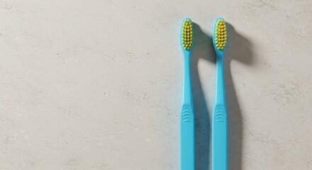 Two vibrant blue toothbrushes with yellow bristles ready for a couple's daily morning dental care routine on a minimalist grey background
