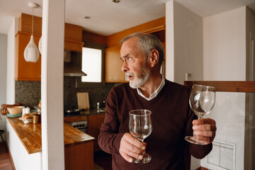 A man talks and looks away while carrying glasses