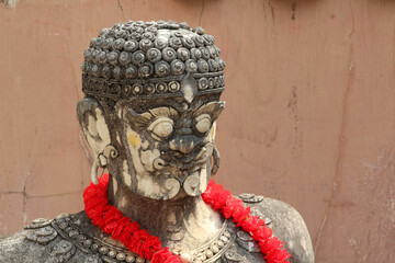 An old giant guardian stucco statue in Wat Phra That Cho Hae