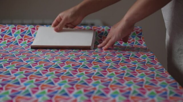 Hands Wrapping a Gift with Colorful Patterned Paper for a Special Occasion