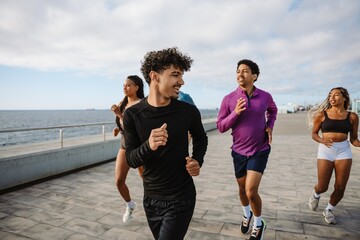 A group of four athletes are running while one of them looks back