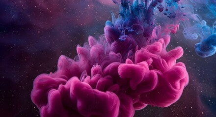Fototapeta premium Abstract image of pink and blue ink swirling together in water against a dark starry background view