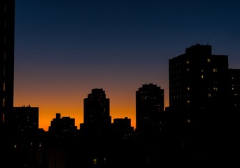 Naklejka premium Silhouette of buildings against a gradient sky at dusk in the city
