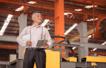 Fototapeta premium Senior experienced technician checking large machine on a production line