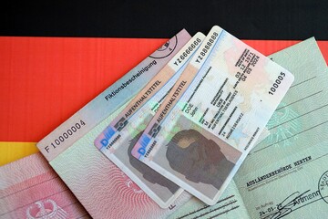 German Permanent resident card and temporary document lies on Germany flag