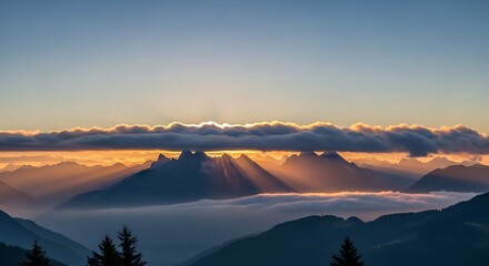 Golden sun rays pierce through clouds over misty mountain peaks at dawn