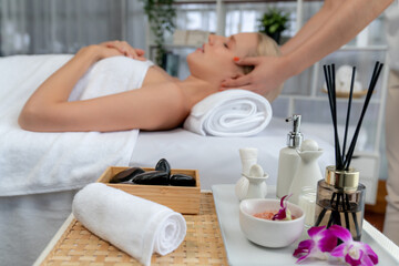 Aromatherapy massage on daylight ambiance or spa salon composition setup with focus decor and spa accessories on blur woman enjoying blissful aroma spa massage in resort or hotel background. Quiescent