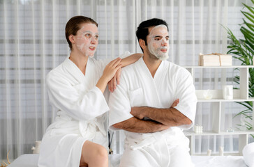 Fototapeta premium Serene modern daylight ambiance of spa salon, couple customer indulges in rejuvenating with facial skincare mask. Facial skin treatment and beauty cosmetology procedure for face. Quiescent