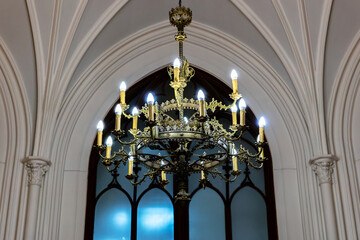 Gothic chandelier hanging in vaulted church nave at dusk
