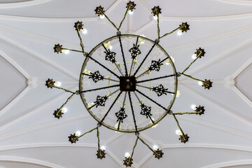 Radial chandelier viewed from below against vaulted ceiling.