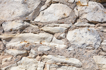 Natural stone masonry wall with irregular rubble and mortar joints
