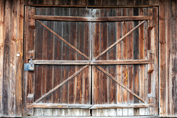 Old wooden barn doors with diagonal braces and metal latch