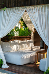 Luxury Lounger with white curtains and pool view 