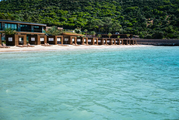 Wooden Loungers in a row on a beautiful beach with turquoise sea water