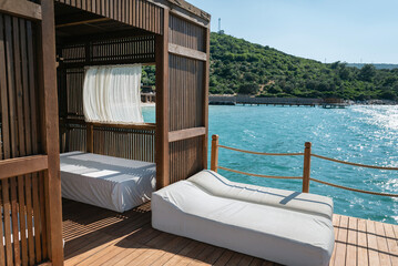 Luxury Lounger with white curtains above the sea 