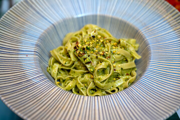 Tagliatelle pasta with pesto sauce, pine nuts and parmesan