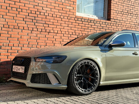 A green Audi RS6 touring cars are parked on street, luxury car exterior. The modern exterior of a premium Germany car Audi RS6 Avant (C7) pistachio color. VAG. 