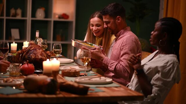 Friends sharing food at thanksgiving dinner table