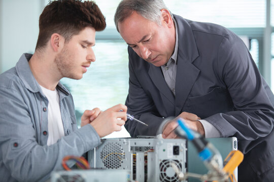 senior boss and his young successful craftsman team - Powered by Adobe